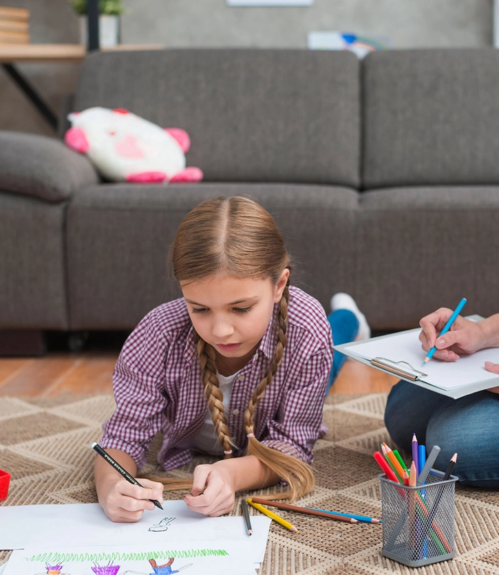 europsychologue expliquant les résultats d'un bilan à un enfant pour l'aider à retrouver la confiance et la réussite scolaire.